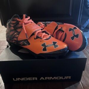 Under Armour Orange and Black football cleats for men.